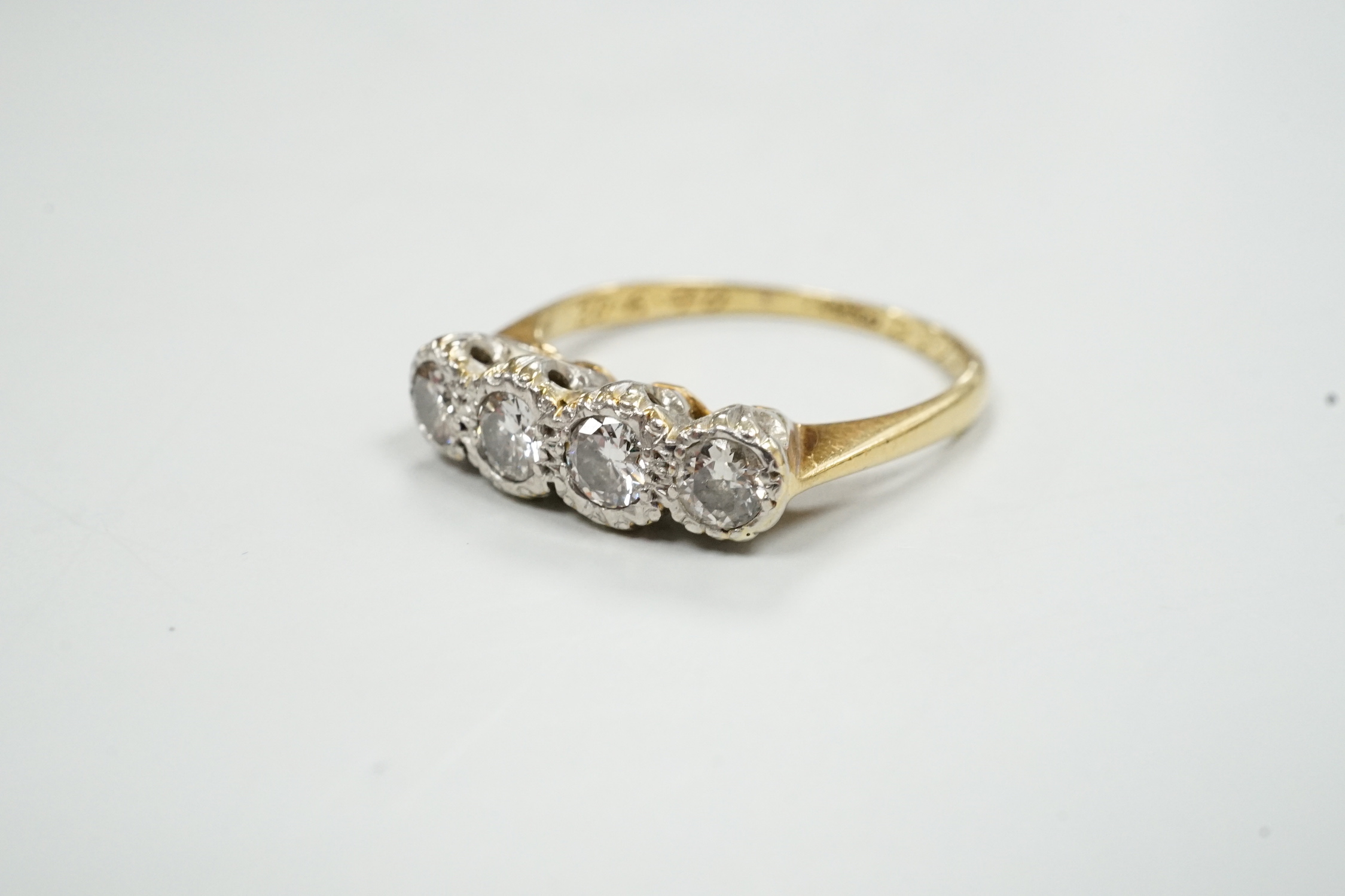 An 18ct, plat and four stone illusion set diamond ring, size M, gross weight 3.1 grams.